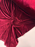 Close-up of red velvet fabric with folds on a white background
