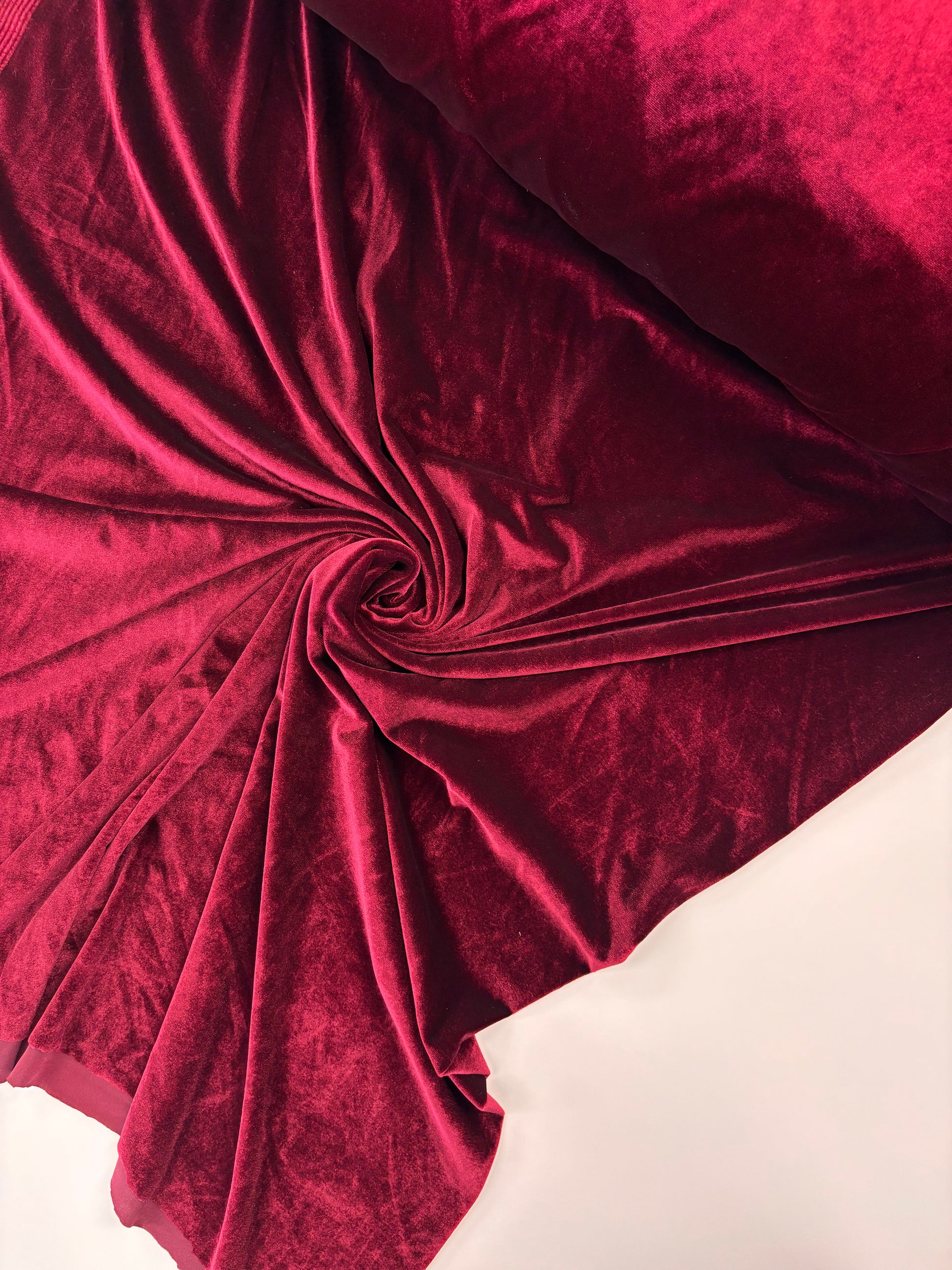 Close-up of red velvet fabric with folds on a white background