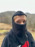 Boy wearing a black fleece balaclava outside