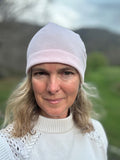 Head shot of woman standing outside wearing a pink beanie. Front view